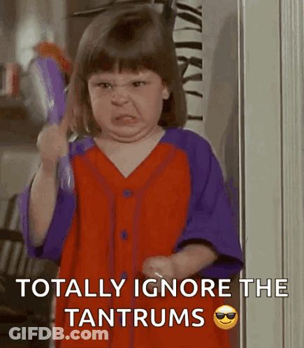A Little Girl Is Making An Angry Face While Holding A Brush And The Words Totally Ignore The Tantrums GIF