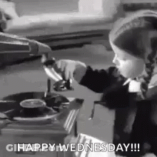 A Little Girl Is Playing A Record On A Record Player And Says `` Happy Wednesday '' . GIF