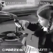 A Little Girl Is Playing Music On A Record Player . GIF