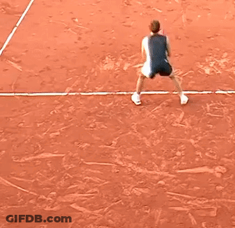 A Little Girl Is Playing Tennis On A Clay Court GIF