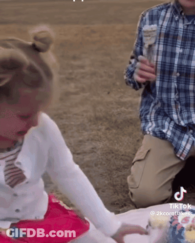 A Little Girl Is Playing With A Cake And A Man Is Holding An Ice Cream Cone GIF