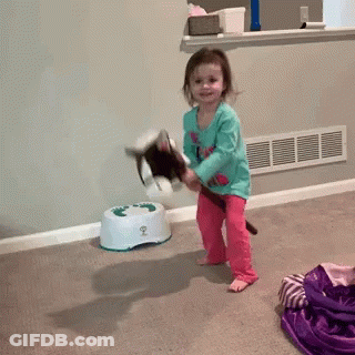 A Little Girl Is Playing With A Stuffed Animal In Front Of A Potty That Has The Number 2 On It GIF