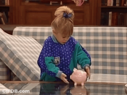 A Little Girl Is Putting Money In A Piggy Bank GIF