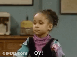 A Little Girl Is Sitting At A Table Making A Funny Face . GIF