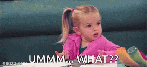 A Little Girl Is Sitting At A Table Making A Funny Face And Asking , `` Ummm ... What ? '' GIF