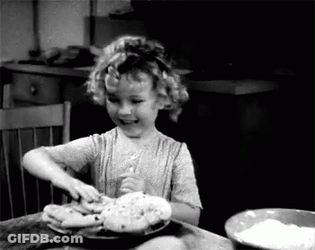 A Little Girl Is Sitting At A Table With A Bowl Of Flour And A Plate Of Food . GIF