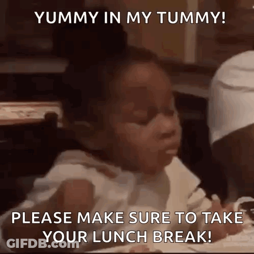 A Little Girl Is Sitting At A Table With A Fork In Her Mouth Eating Food . GIF