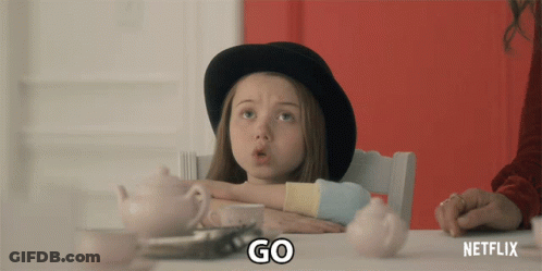 A Little Girl Is Sitting At A Table With A Netflix Logo On The Bottom GIF