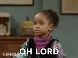 A Little Girl Is Sitting At A Table With The Words `` Oh Lord '' On Her Face . GIF