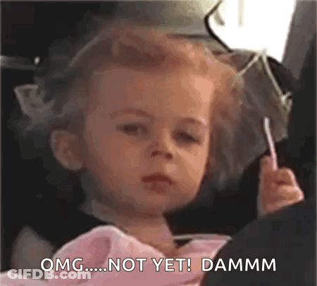 A Little Girl Is Sitting In A Car Seat Eating A Lollipop And Making A Funny Face . GIF