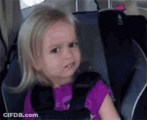 A Little Girl Is Sitting In A Car Seat Wearing A Seat Belt . GIF