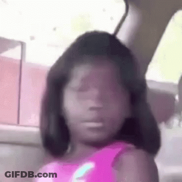 A Little Girl Is Sitting In A Car With Her Eyes Closed And Making A Funny Face . GIF