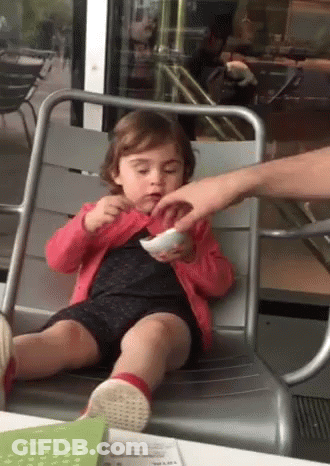 A Little Girl Is Sitting In A Chair Eating A Bowl Of Food GIF