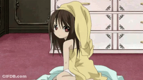 A Little Girl Is Sitting On A Bed With A Yellow Towel On Her Head . GIF