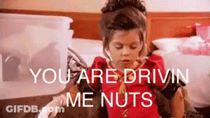 A Little Girl Is Sitting On A Bed With The Words `` You Are Drivin Me Nuts '' Behind Her . GIF