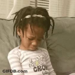 A Little Girl Is Sitting On A Couch Wearing A Shirt That Says " It 'S The Crow Bites " GIF