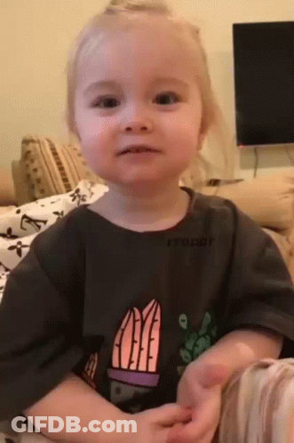 A Little Girl Is Sitting On A Couch Wearing A T-Shirt With A Cactus On It . GIF