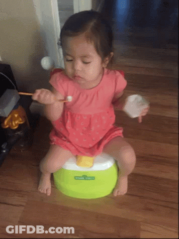 A Little Girl Is Sitting On A Green Potty With Sesame Street Written On It GIF