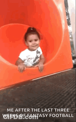 A Little Girl Is Sitting On An Orange Slide With The Caption Me After The Last Three Weeks Of Fantasy Football GIF