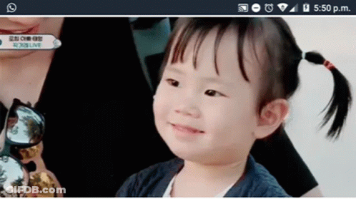 Smiling Girl Looking At Cell Phone GIF