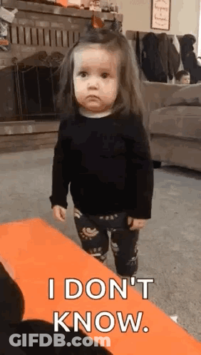 A Little Girl Is Standing In A Living Room And Making A Funny Face . GIF