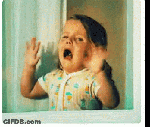 A Little Girl Is Standing In Front Of A Window With Her Mouth Open . GIF
