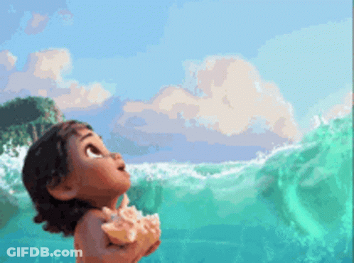 A Little Girl Is Standing In The Ocean Holding A Seashell GIF