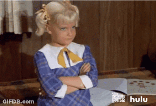 A Little Girl Is Standing With Her Arms Crossed In Front Of A Hulu Ad GIF