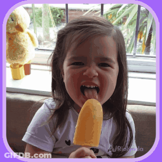 A Little Girl Is Sticking Her Tongue Out While Eating An Ice Cream GIF