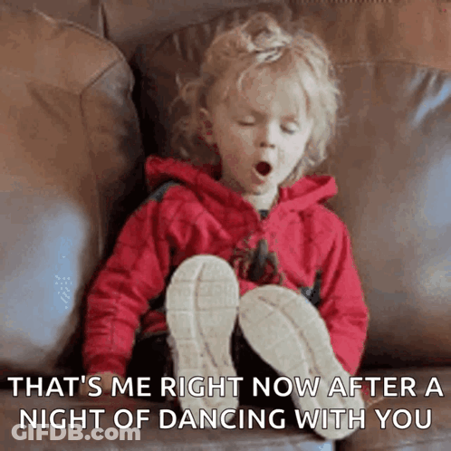 A Little Girl Is Yawning While Sitting On A Couch With Her Legs Crossed GIF