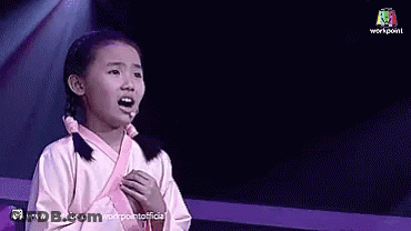 A Little Girl Singing Into A Microphone On Stage GIF