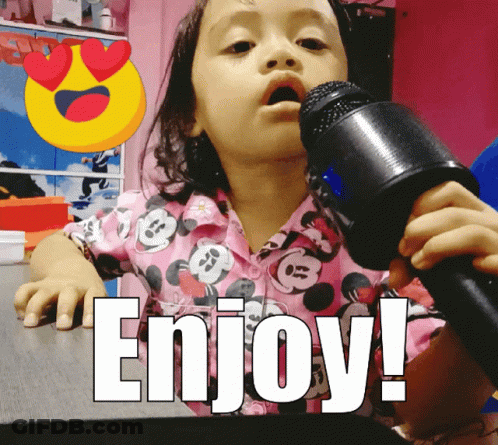 A Little Girl Singing Into A Microphone With The Word Enjoy Written Below Her GIF