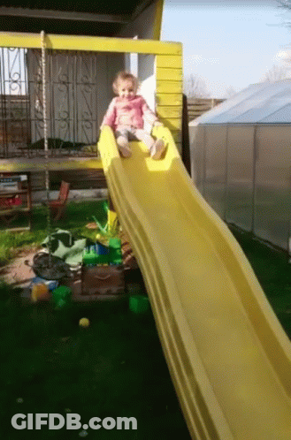 A Little Girl Sits On A Yellow Slide GIF