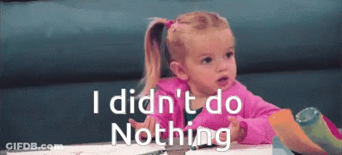 A Little Girl Sitting At A Table With The Words " I Did N't Do Nothing " On The Bottom GIF