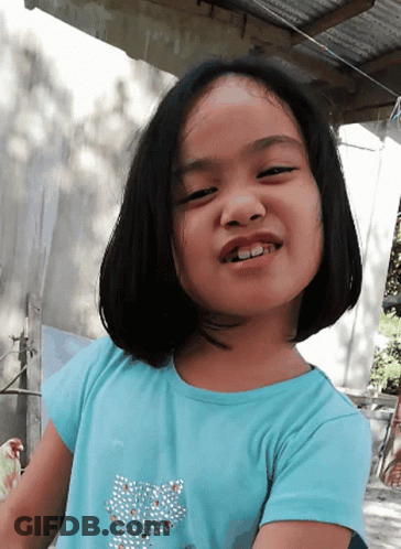 A Little Girl Wearing A Blue Shirt With A Butterfly On It GIF