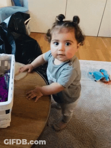A Little Girl Wearing A Gray Shirt That Says ' I Love You ' GIF