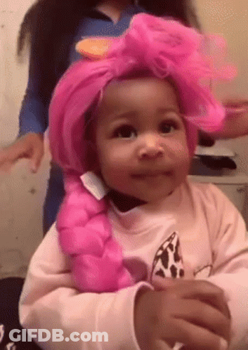 A Little Girl Wearing A Pink Wig And A Pink Braid . GIF