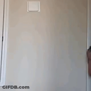 A Little Girl Wearing A Rainbow Tank Top Is Standing In Front Of A Wall GIF