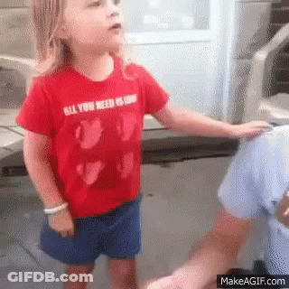 A Little Girl Wearing A Red Shirt That Says All You Need Is Love Is Standing Next To A Man . GIF