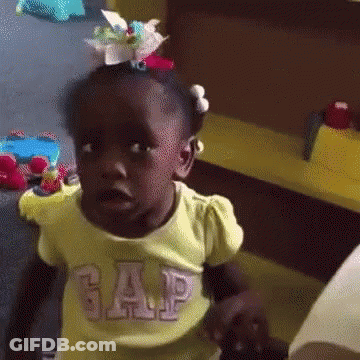 A Little Girl Wearing A Yellow Gap Shirt Is Making A Funny Face GIF