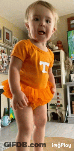 A Little Girl Wearing An Orange T-Shirt And Orange Tutu GIF