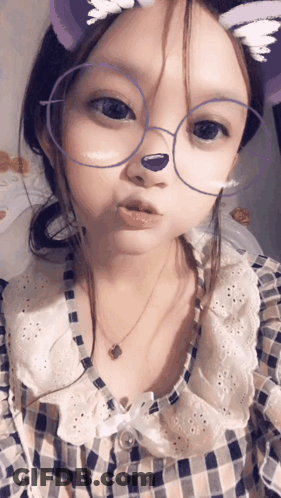 A Little Girl Wearing Glasses And A Plaid Shirt GIF
