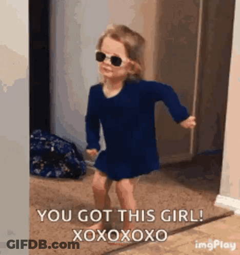 A Little Girl Wearing Sunglasses And A Blue Dress Is Dancing In A Room . GIF