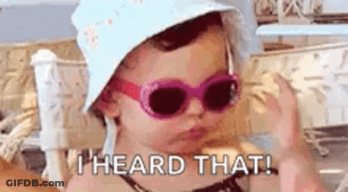A Little Girl Wearing Sunglasses And A Hat Is Making A Funny Face . GIF