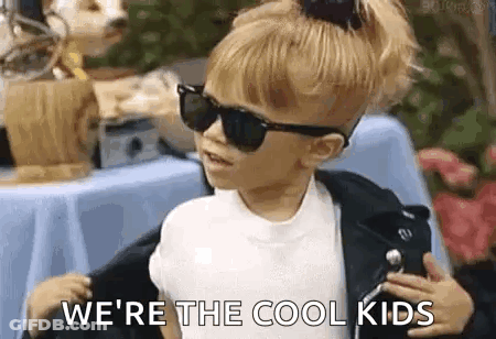 A Little Girl Wearing Sunglasses And A Leather Jacket . GIF