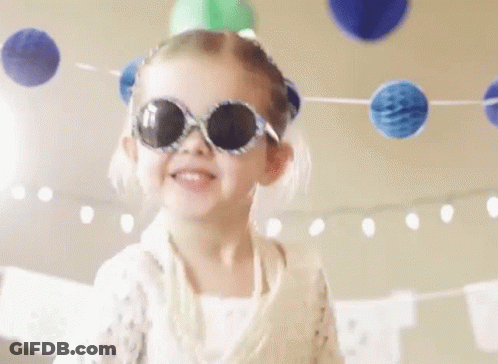 A Little Girl Wearing Sunglasses And A Party Hat Is Dancing At A Birthday Party . GIF