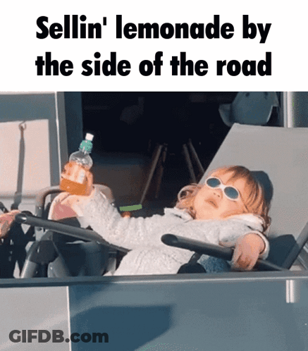 A Little Girl Wearing Sunglasses Is Sitting On A Chair Holding A Bottle Of Lemonade GIF
