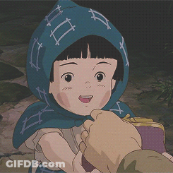 A Little Girl With A Blue Scarf Around Her Head Is Being Held By A Person GIF