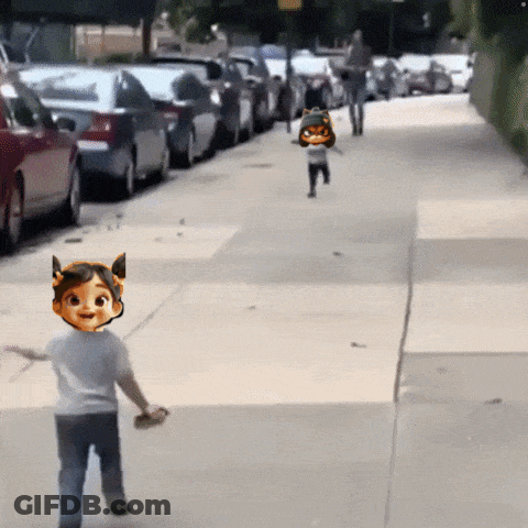 A Little Girl With A Cat On Her Head Is Running Down The Sidewalk GIF