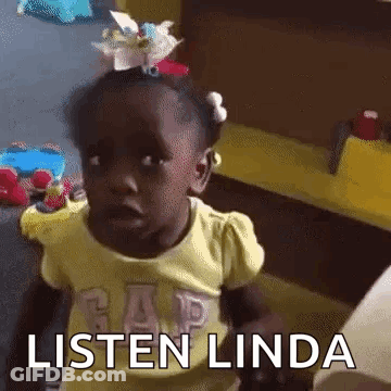 A Little Girl With A Flower In Her Hair Is Sitting At A Table And Says Listen Linda . GIF